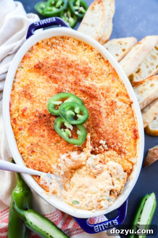 Zingy Cheesy Jalapeno Spread 3 spoon in pan of baked cheese appetizer in pan