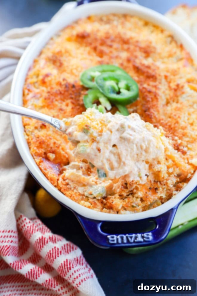 Zingy Cheesy Jalapeno Spread 8 Cheesy dip being lifted with a spoon out of the pan
