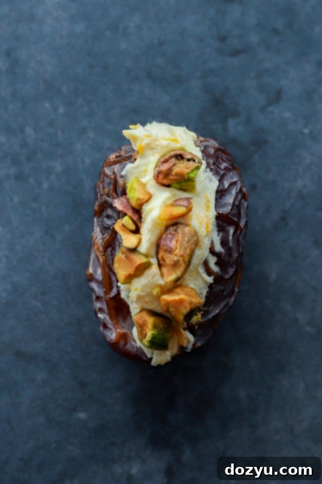 Elevate Your Dates: 4 Irresistible Stuffings 4 A close-up of a mascarpone and orange zest stuffed date, topped with pistachios