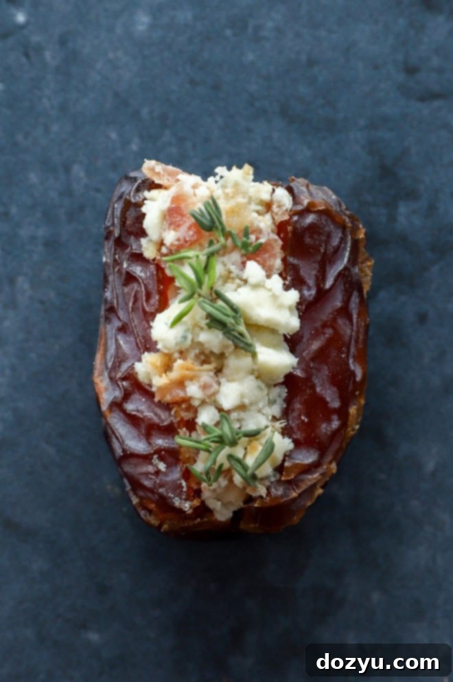 Elevate Your Dates: 4 Irresistible Stuffings 6 A bacon and blue cheese stuffed date, garnished with fresh thyme