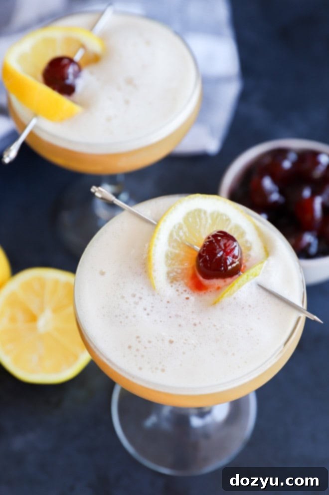The Disaronno Sour 7 Disaronno sour cocktails in glasses with lemon and cherry garnish