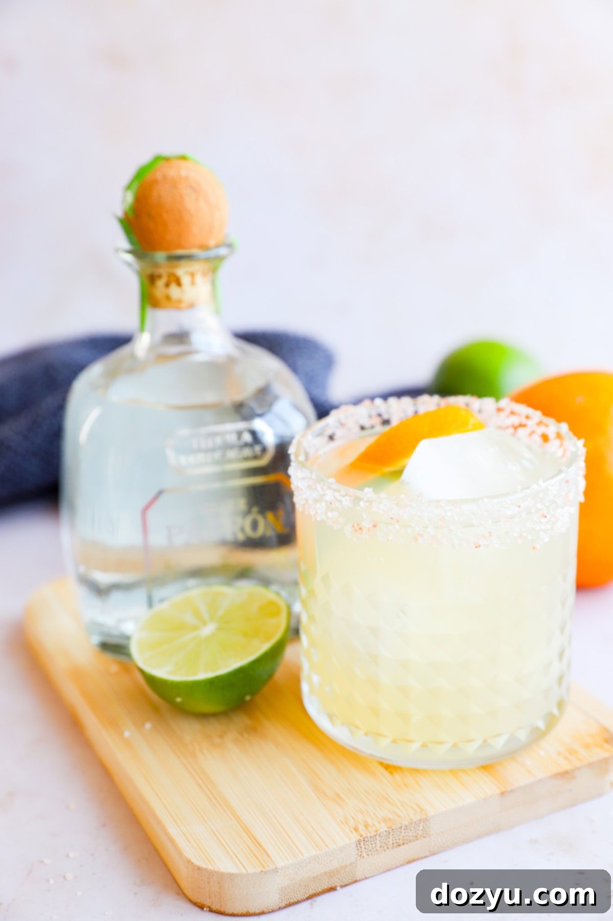 The Patron Margarita 10 Patron bottle with a margarita in a salt rimmed glass and citrus garnish