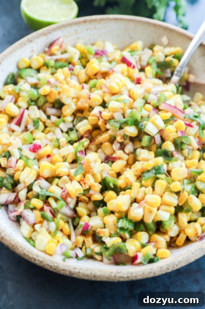 Smoky Roasted Corn Salsa 2 easy appetizer with tons of vegetables in a bowl with a spoon