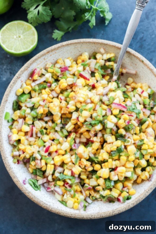 Smoky Roasted Corn Salsa 9 roasted chili corn salsa in a bowl with a lime and cilantro