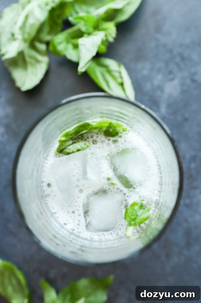 Gin Basil Smash 4 Fresh basil and lemon muddled in a cocktail shaker, preparing for a Gin Basil Smash.
