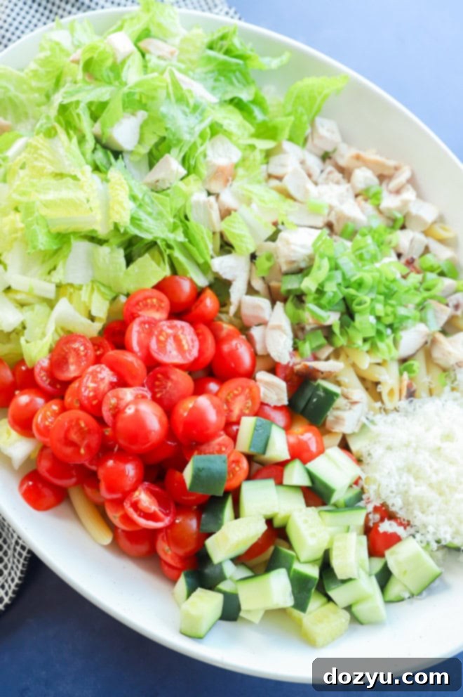 Creamy Caesar Chicken Pasta 4 chicken caesar pasta salad ingredients in a bowl before adding dressing