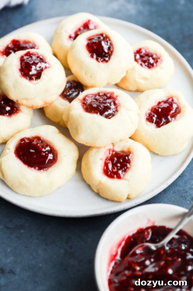 Jammy Raspberry Thumbprints 6 easy shortbread with jam inside and bowl of jam to the side