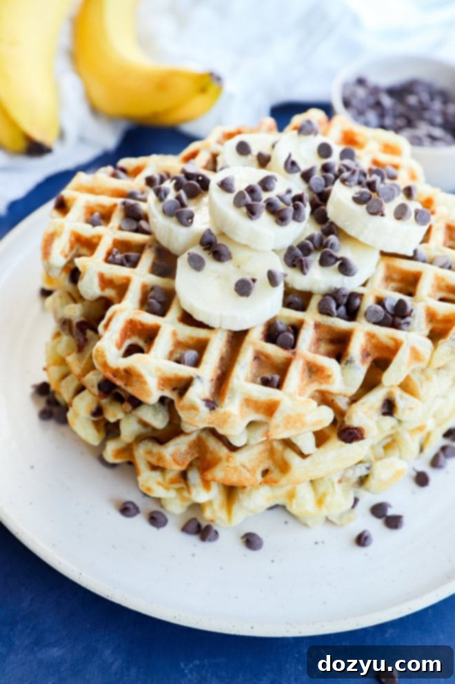 Ultimate Banana Chocolate Chip Waffles 6 A beautiful plate of brunch goodies featuring a fresh banana, chocolate chips, and other fruits alongside golden waffles