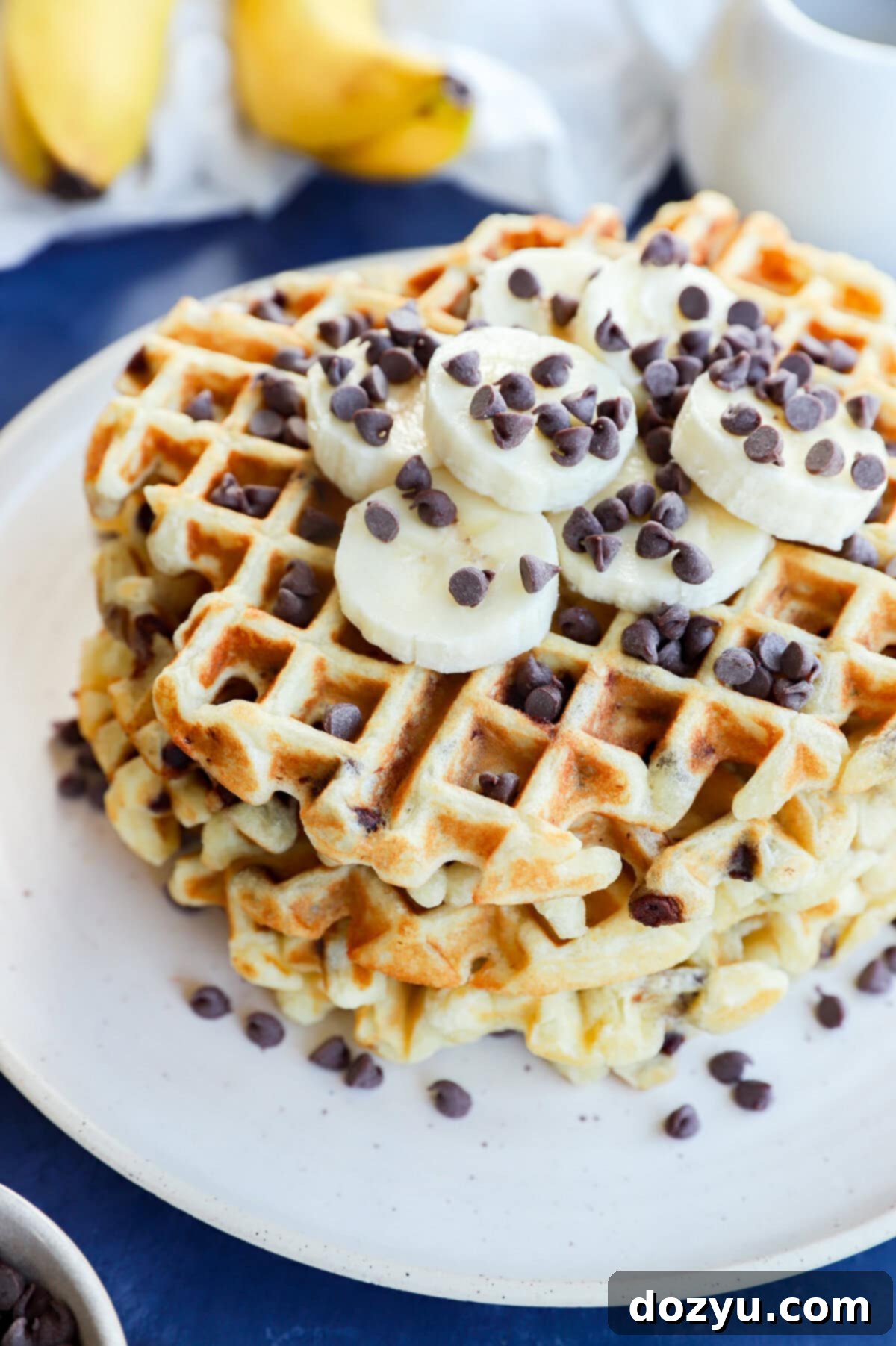 Ultimate Banana Chocolate Chip Waffles 9 Stack of fluffy banana chocolate chip waffles with fresh banana slices and melted chocolate chips