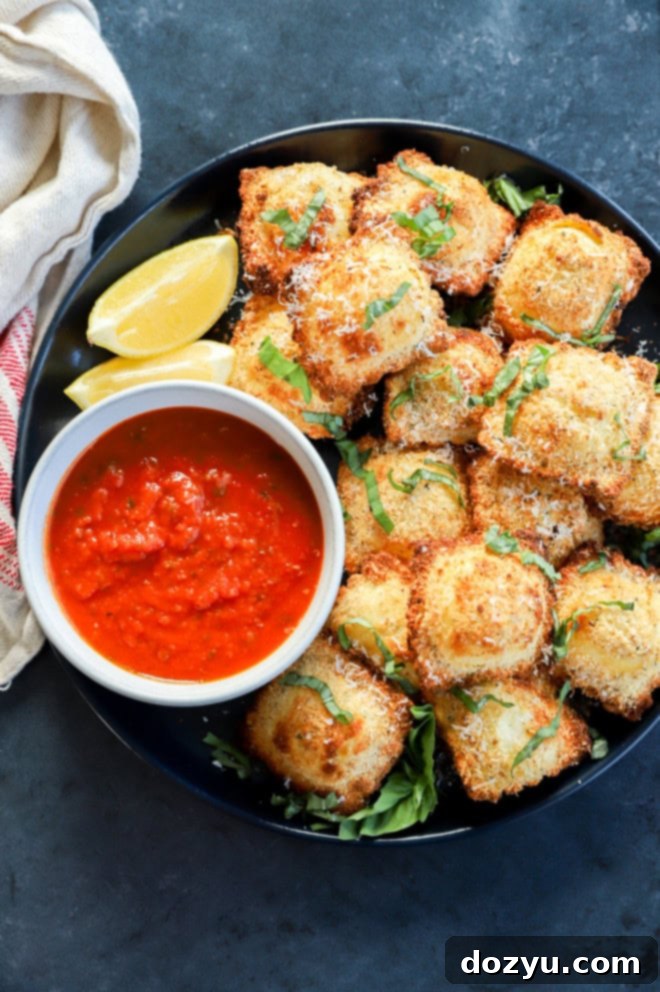 Golden Air Fryer Ravioli 7 toasted cheese pasta on a plate with dipping sauce