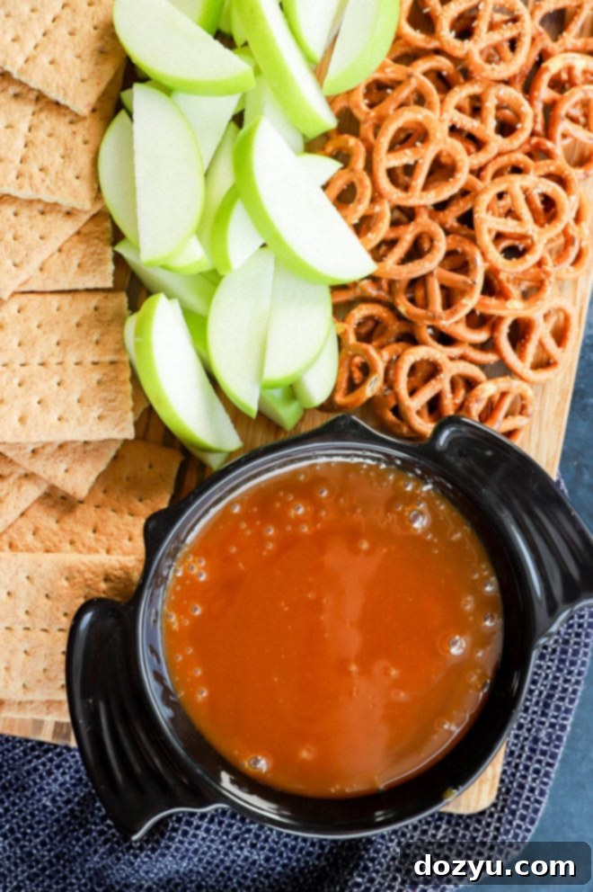 Caramel Apple Delight 5 Homemade caramel apple dip in a bat-shaped bowl on a platter with pretzels, graham crackers, and apple slices