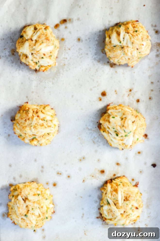 Golden Baked Crab Cakes 7 baked crab cakes on sheet pan after baking