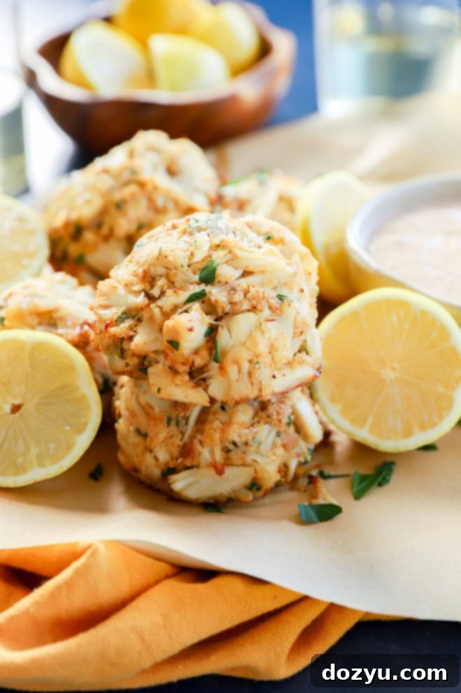 Golden Baked Crab Cakes 9 stack of easy seafood appetizer with fresh lemons in bowl and white wine and sauce