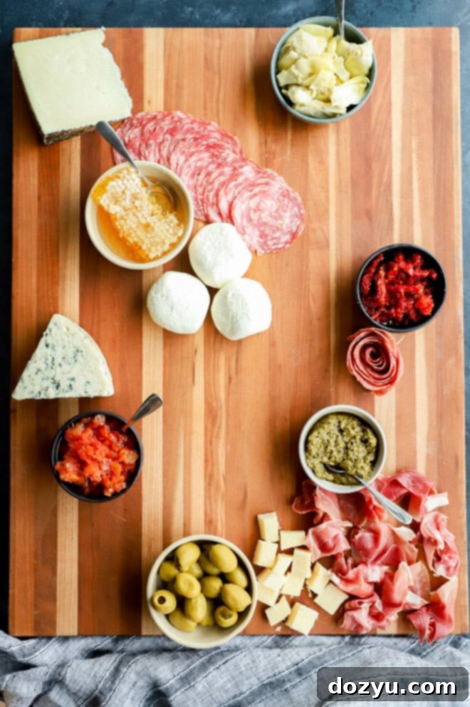 The Ultimate Italian Grazing Board 7 meats added to cutting board serving platter with cheeses and bowls