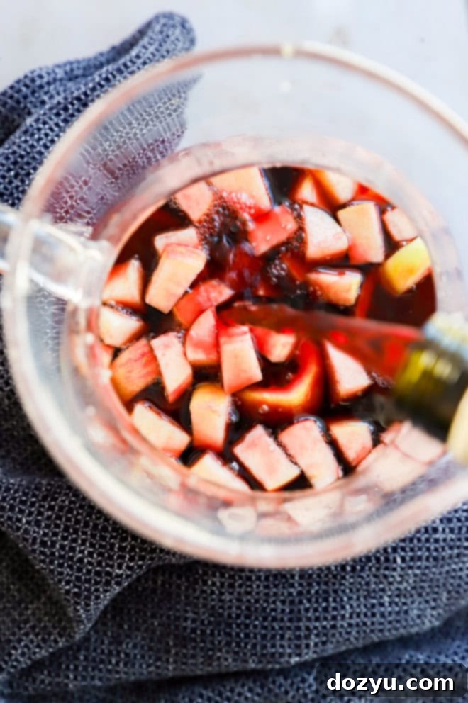 Timeless Red Sangria 4 Pouring Spanish red wine into a red sangria pitcher filled with fruit