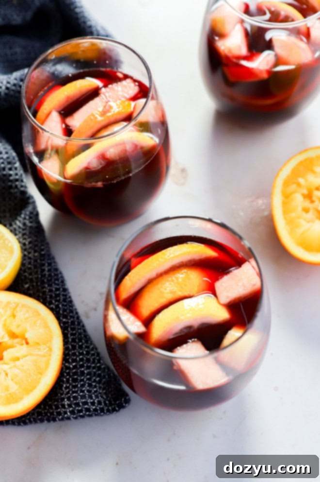 Timeless Red Sangria 7 Red sangria in wine glasses with fresh fruit and a dark background