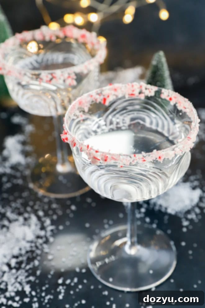 Refreshing Peppermint Martini 5 Two festive peppermint martinis in coupe glasses with candy cane rims, ready to be enjoyed during the holidays