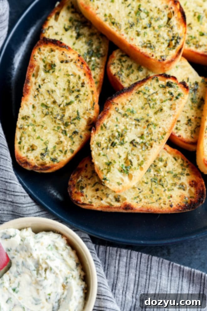 Artisan Sourdough Garlic Toast 3 Slices of golden sourdough garlic toast on a plate next to a bowl of fresh garlic herb butter