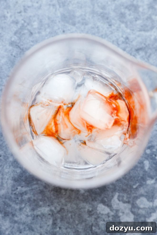 Rose Gin Elixir 4 bitters added to mixing glass with ice
