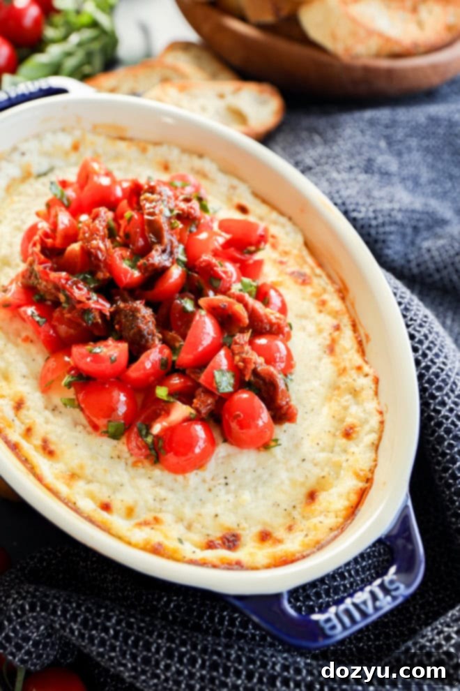 Warm Goat Cheese Dip 2 baked goat cheese appetizer in baking dish with tomato topping