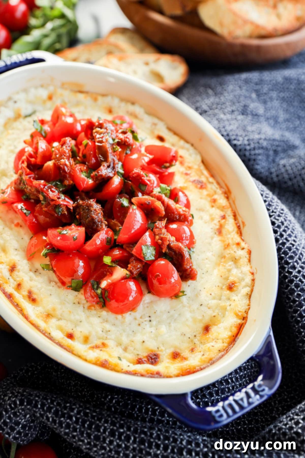 Warm Goat Cheese Dip 9 baked goat cheese appetizer in baking dish with tomato topping