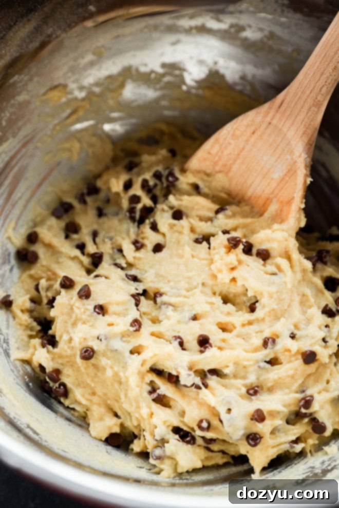 Irresistible Mini Chocolate Chip Bites 7 mini chocolate chip muffins batter in a bowl with wooden spoon