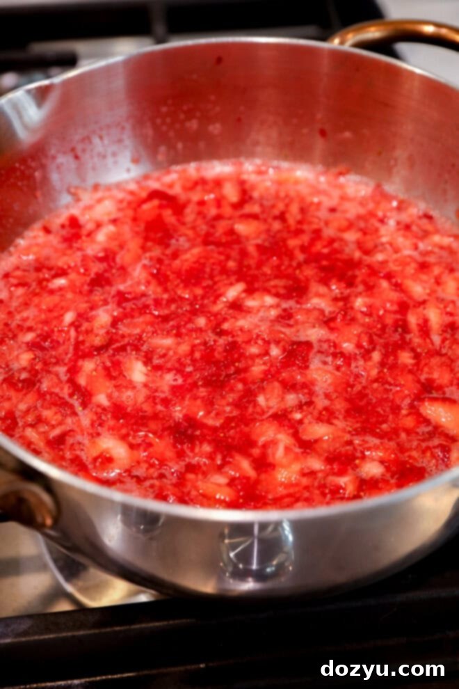 making strawberry filling on the stovetop in a saucepan