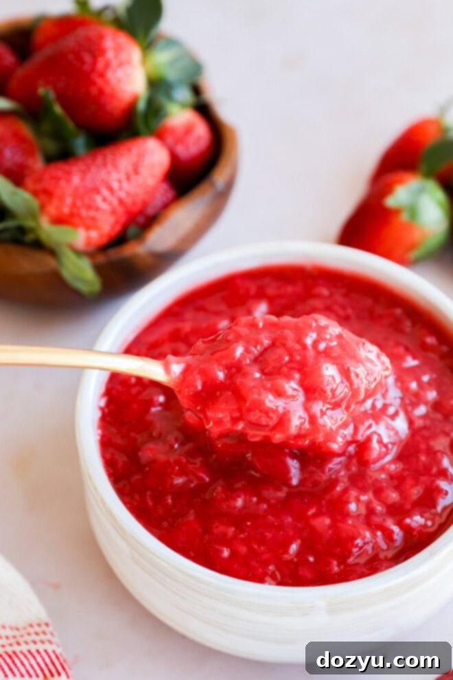 spoon lifting out berry compote from a bowl