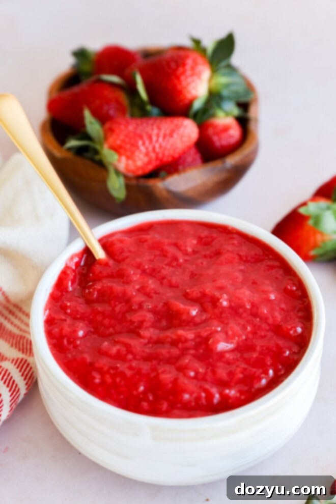 Luscious Strawberry Filling 9 bowl of berry compote with spoon and bowl full of strawberries in the background