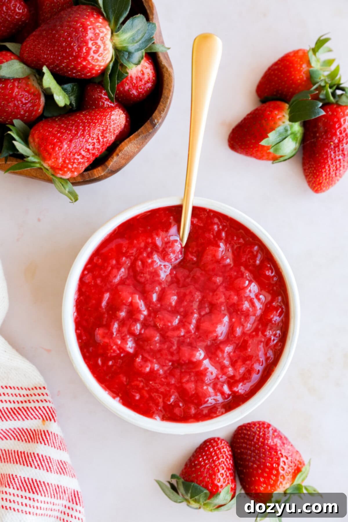 strawberry filling in a bowl with fresh strawberries all around