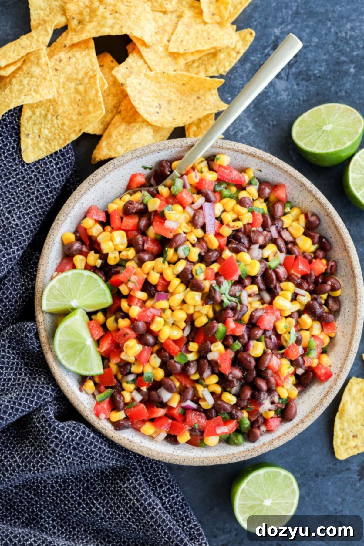 Fiesta Black Bean Corn Dip 9 Bowl of fresh vegetables to make an appetizer with chips around and fresh limes
