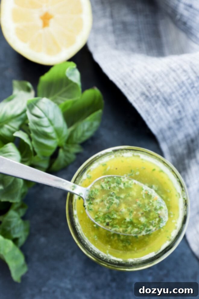 The Magic of Basil Oil 7 A large serving spoon scooping fresh herb condiment from a white bowl, ready to be added to a dish, set on a grey linen.