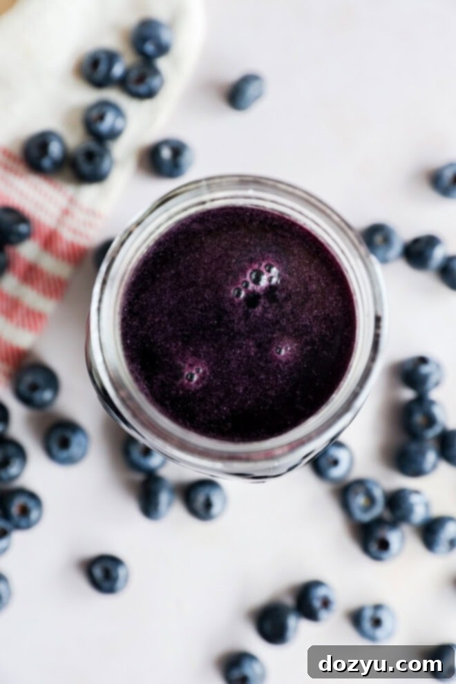 Luscious Blueberry Syrup 8 berry sweetener in mason jar with fresh berries all around with linen