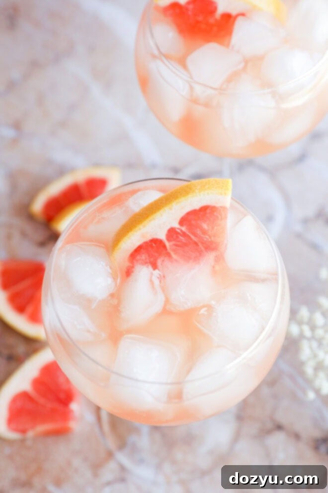 Rosé Elderflower Spritz 2 Rosé Elderflower Spritz Cocktail in stemmed wine glasses with fresh grapefruit wedges