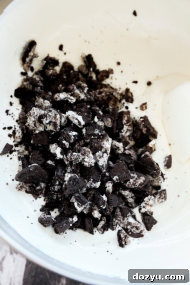 Ultimate Oreo Swirl Ice Cream 5 Ice cream base in large mixing bowl with pile of crushed Oreos