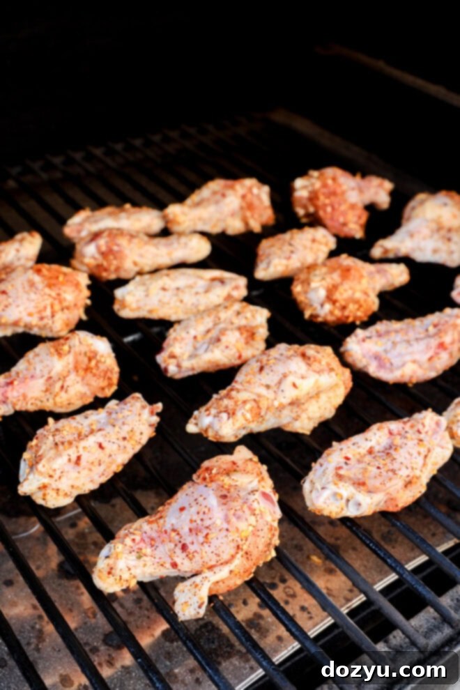 Foolproof Smoked Chicken Wings 5 Raw chicken wings laid out on a smoker grate, ready to be cooked.
