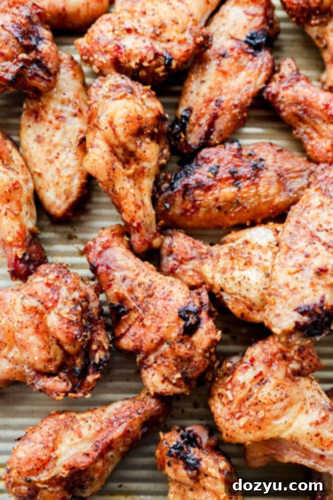 Foolproof Smoked Chicken Wings 7 Dry rub smoked chicken wings arranged on a baking sheet, showcasing their golden crust.