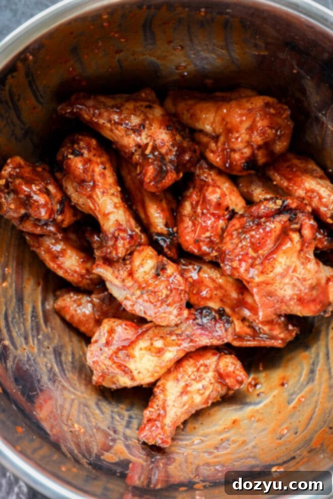 Foolproof Smoked Chicken Wings 8 Smoked chicken wings in a large bowl, beautifully tossed with a rich BBQ sauce.