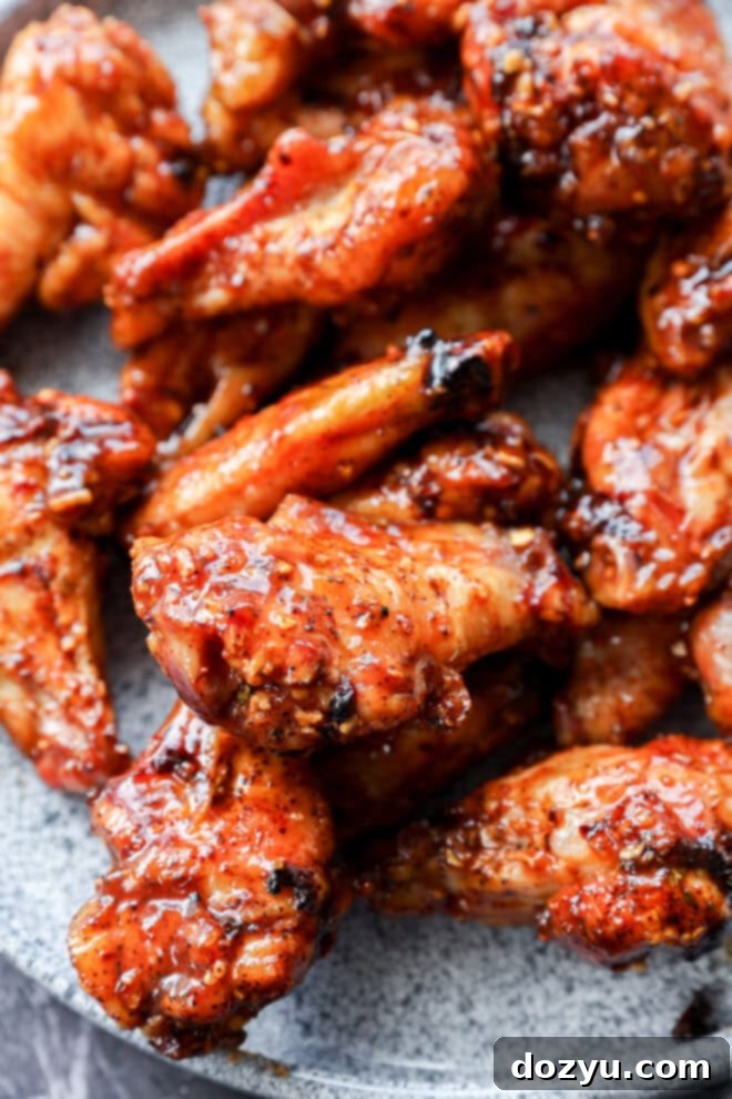 Foolproof Smoked Chicken Wings 9 A plate of perfectly cooked smoked chicken wings, generously tossed with BBQ sauce and ready to be served.