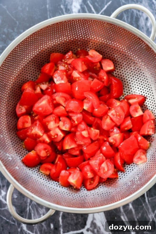 Tuscan Summer Bread Salad 5 chopped tomatoes in colander draining over a bowl