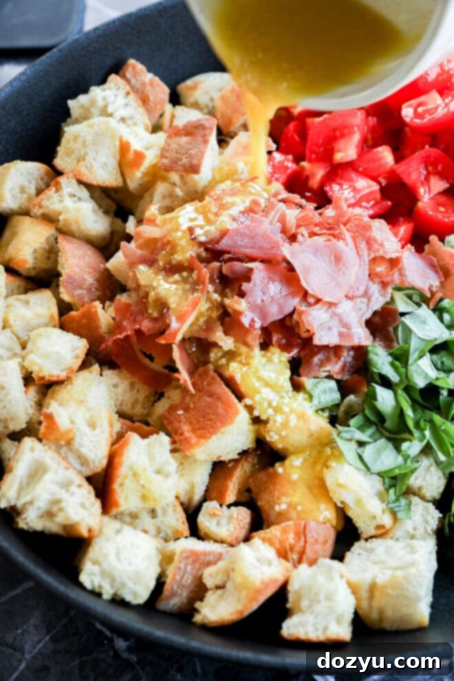 Tuscan Summer Bread Salad 10 Drizzling dressing over Panzanella Toscana in serving bowl