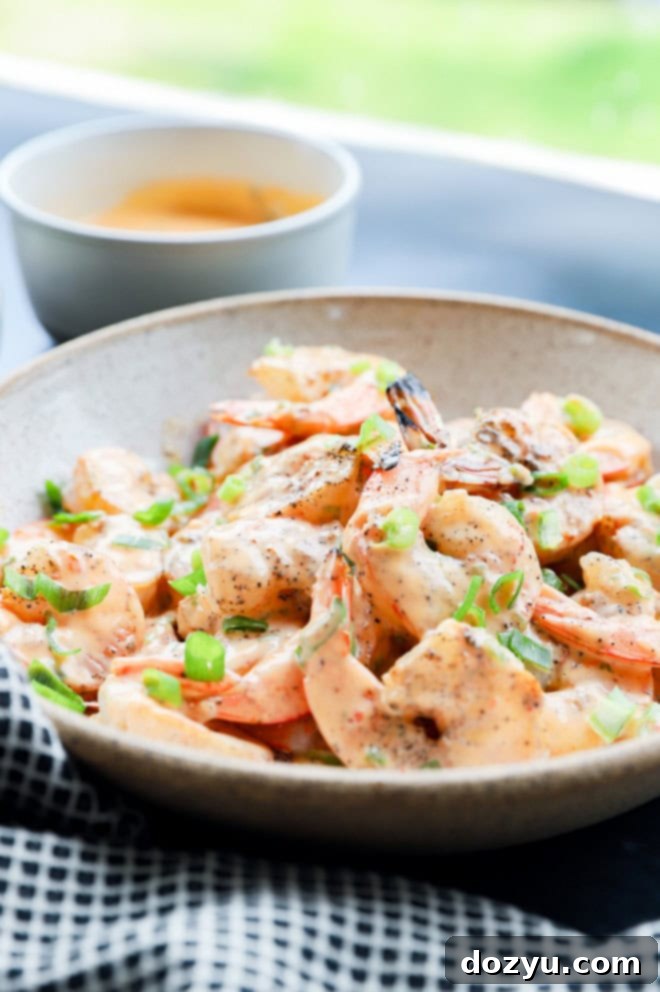 Sizzling Bang Bang Prawns 3 Bang bang shrimp in a bowl with sauce and scallions, ready to serve