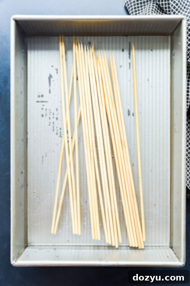 Sizzling Bang Bang Prawns 5 Wooden skewers soaking in water in a shallow container to prevent burning on the grill.