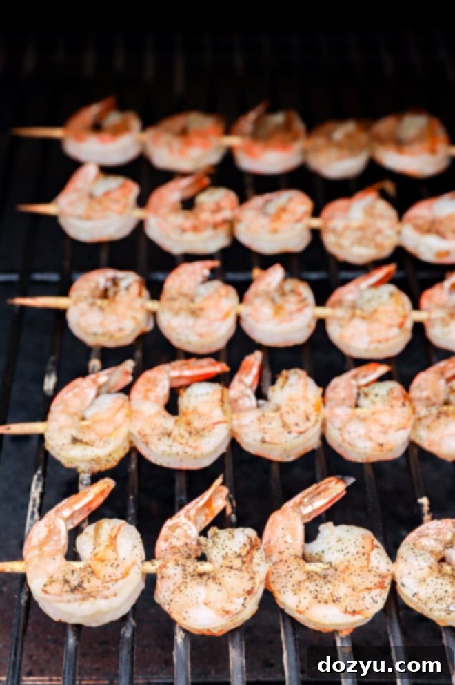 Sizzling Bang Bang Prawns 7 Grilled shrimp skewers cooking on a hot grill, showing their vibrant color change.