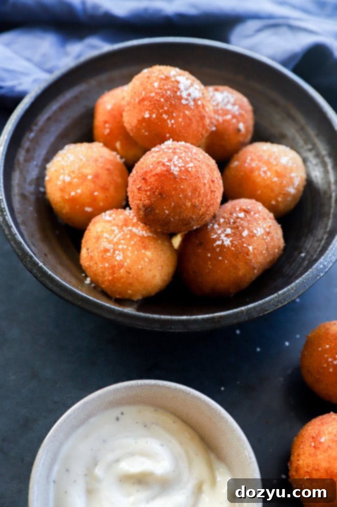 Golden fried balls of cheese with salt on top in a pile in a bowl