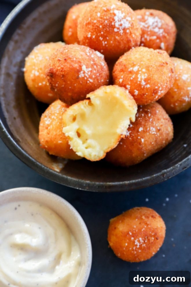 Cheesy croquette cut in half with gooey melted cheese inside