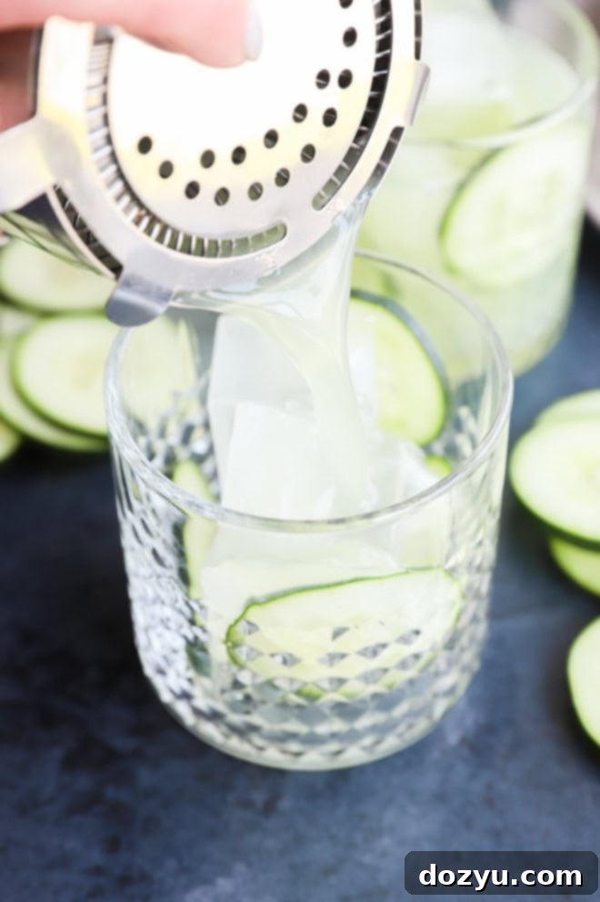 Verdant Margarita 4 straining cucumber margarita into a cocktail glass with fresh cucumber