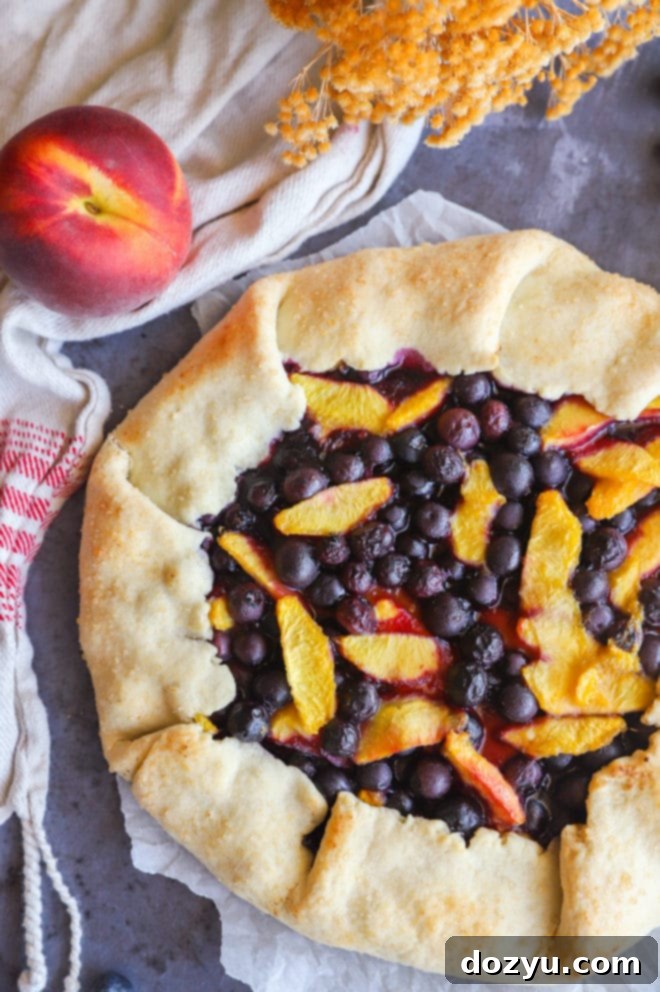 Overhead image of peach galette with blueberries, served with vanilla ice cream