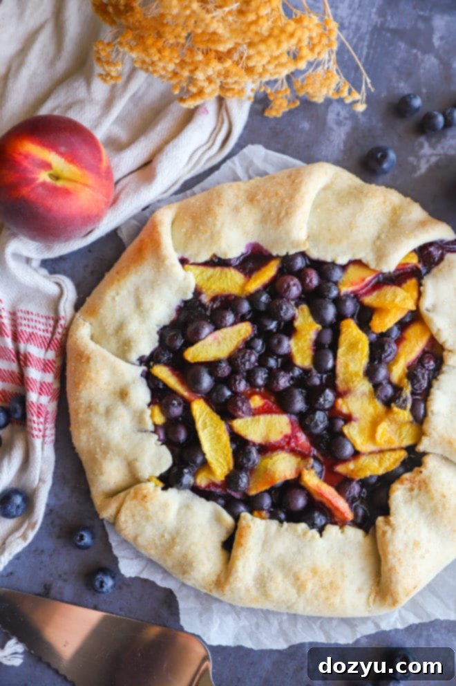 Fresh summer fruit galette with peaches and blueberries, showing the rustic folded crust