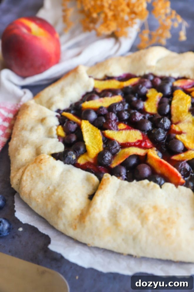 A vibrant peach blueberry galette cooling on a wire rack, showcasing its golden crust and juicy fruit